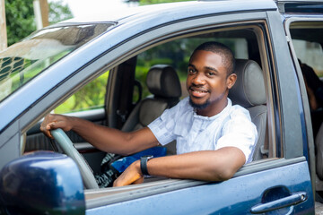 Portrait of a young black african handsome driver in taxi car - obrazy, fototapety, plakaty