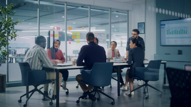 Multi-Ethnic Office Conference Room Meeting: Diverse Team of Young Entrepreneurs, Specialists Talk, Use TV for infographics. Smiling Businesspeople Discuss Investment Strategy in e-commerce Startup
