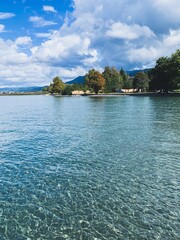 Fototapeta na wymiar Beautiful azure lake with transparent water, pebbles bottom, sunny day