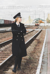 European or American train conductor is on his duty on a platform and other trains. Railway, steam trains .Train controller on the train, near a locomotive