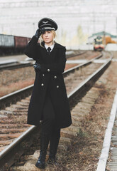 European or American train conductor is on his duty on a platform and other trains. Railway, steam trains .Train controller on the train, near a locomotive