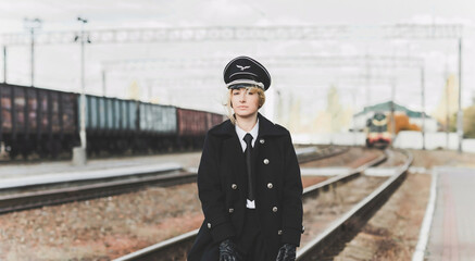 European or American train conductor is on his duty on a platform and other trains. Railway, steam...