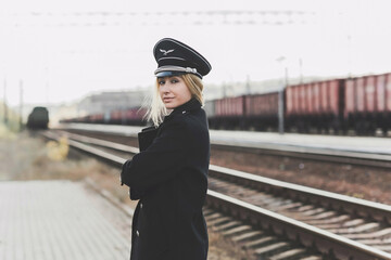 European or American train conductor is on his duty on a platform and other trains. Railway, steam trains .Train controller on the train, near a locomotive