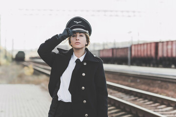 European or American train conductor is on his duty on a platform and other trains. Railway, steam...