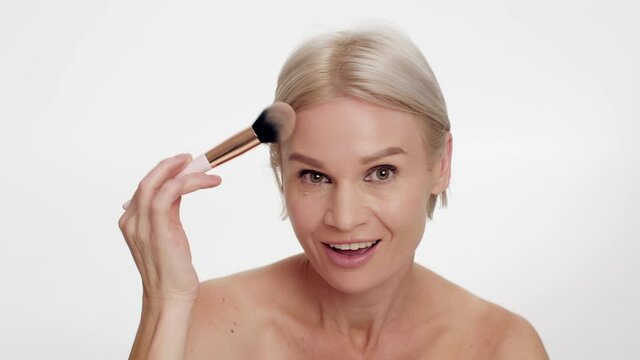 Beautiful Middle Aged Woman Applying Powder On Face With Makeup Brush