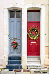 Fototapeta na wymiar Front doors of twin townhouses decorated with Christmas crowns