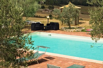 A pair of poolside sofas in the Italian countryside during a stormy day (Tuscany, Italy, Europe) - 464047342