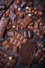 Chocolate background with lots of bars, nuts and cocoa beans