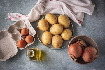 ingredientes para preparar una tortilla de patata: huevos, patatas, cebollas y aceite de oliva
