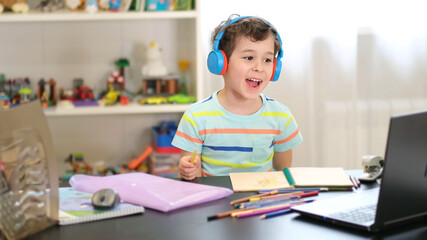Learn on your schedule. Distance learning online education. A schoolboy boy studies at home and...