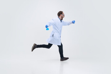 Portrait of running man, chemist, doctor in action and motion isolated on white background. Concept of healthcare, pharmaceuticals, medicine