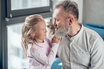 A small cute girl looking happy spending time with her father