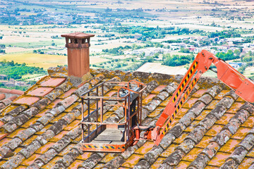 Aerial mechanical platform with protective basket to repair a roof safely in a construction site