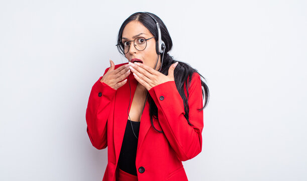 pretty hispanic woman covering mouth with hands with a shocked. telemarketing concept