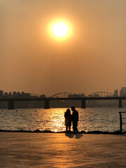 Naklejka na ściany i meble couple on the river at sunset