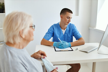 Obraz na płótnie Canvas elderly woman talking to doctor professional consultant