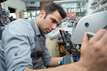 handyman making door keys copies