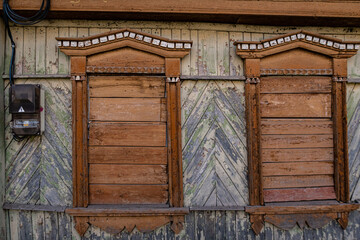 two boarded up windows in an old wooden house