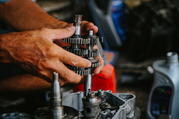 Maintenance and repair of the motorcycle engine transmission system by a mechanic.
