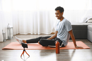 Fototapeta premium Young sporty man filming morning exercise on camera