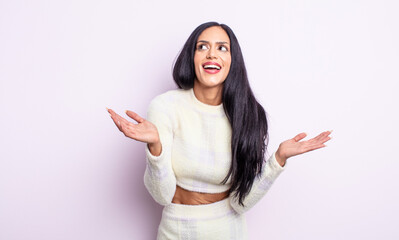 pretty hispanic woman feeling happy and astonished at something unbelievable
