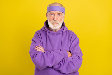 Photo of aged man pensioner crossed hands serious wear sportive clothes isolated over yellow color background
