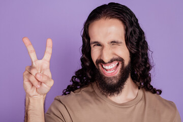 Photo of young latin man wink eye good mood show peace v-symbol isolated on violet color background