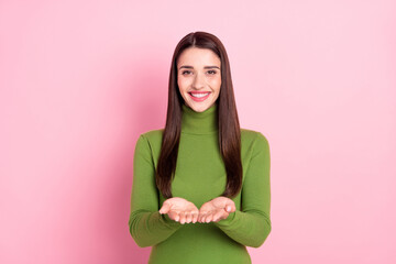 Photo of pretty happy cheerful young woman hold hands give you object empty space isolated on pink color background