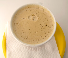 home made cup of coffee in a glass in a plate with a napkin 