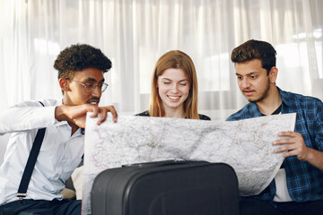 Fototapeta premium Group of diverse friends looking at map in the bright room