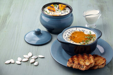 Pumpkin cream soup with cream, black cumin seeds, herbs and toasted bread
