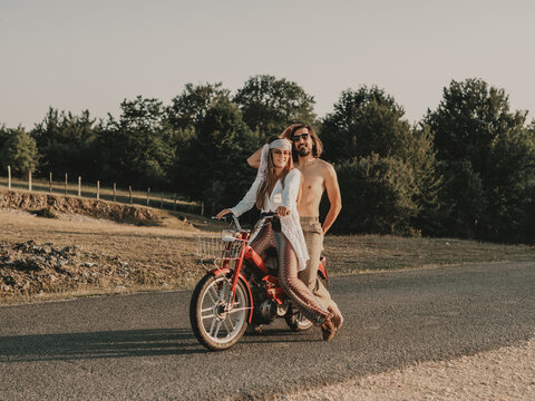 Hippie couple riding on moped