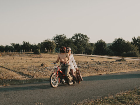 Hippie couple riding on moped
