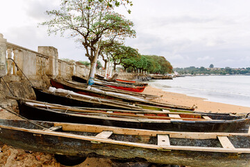 Old boats on sandy shore near ocean on tropical island