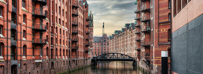 panoramic view of canal and historic buildings in old warehouse district Speicherstadt in Hamburg,...