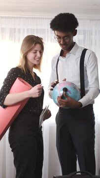 Man and woman looking at globe in a room