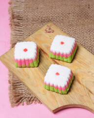 Putu Ayu cake is in the form of a box with three colors, namely green, red and white. This cake has a soft and tender texture. Putu Ayu can be found in markets or shops. Market snacks. Focus blur.