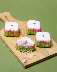 Putu Ayu cake is in the form of a box with three colors, namely green, red and white. This cake has a soft and tender texture. Putu Ayu can be found in markets or shops. Market snacks. Focus blur.