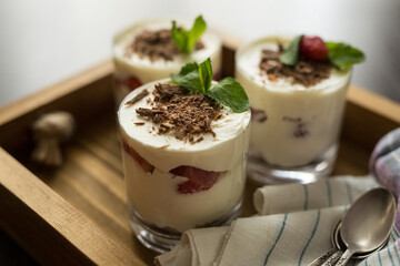 Dessert in a transparent glass on a wooden tray