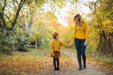 Obraz premium Young mother with her little daughter in an autumn park