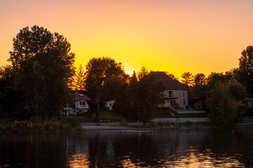 Sunset behind large houses on the shore. Ottawa, Ontario, Canada