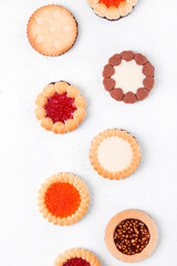 Cookies assortment with fillings on the white table. Flat lay. Food background