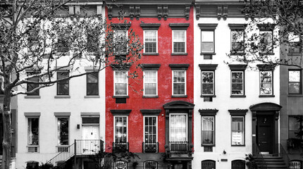 Red brick building isolated against row of old black and white buildings in Manhattan New York City