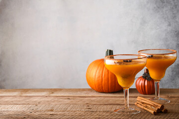 Pumpkin cocktail with cinnamon, orange juice and cocoa in glass mugs. Festive cocktail Halloween...