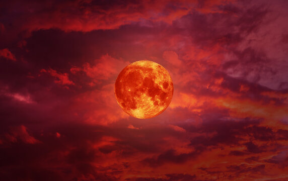 blood moon concept of a red full moon in black sky with cloud.