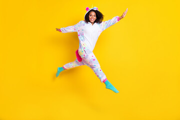 Fototapeta na wymiar Full body photo of young afro woman happy positive smile jump go walk childish pajamas isolated over yellow color background