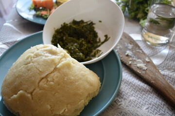 close up photo of a plate of ugali and Sukuma. The main food that is eaten in Kenya