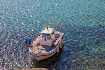 Greek Fishing Boat. Isolated. Greek typical fishing vessel moored on the rocks. Copy Space. Stock Image.