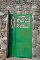 Green Metal Door. Isolated. Bright green entrance door . Stone wall in the background. Stock Image.