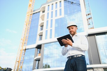 Fototapeta premium Architect in helmet near new building